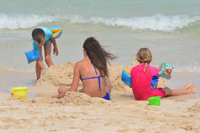 Familie mit Schulkindern am Strand